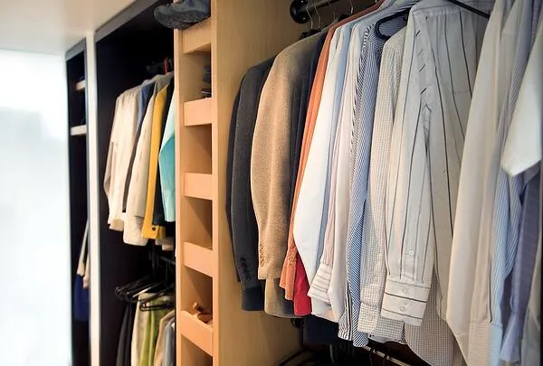 reach in closet full of shirts organized for fall and winter