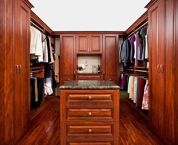 Walk in closet organization system with beautful wood cabinets and bench