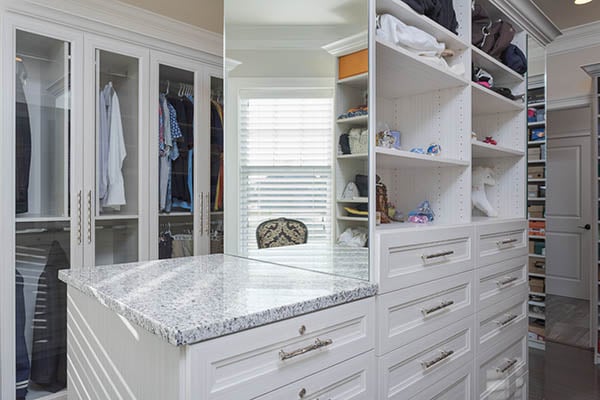 Organized walk-in closet with glass see through doors