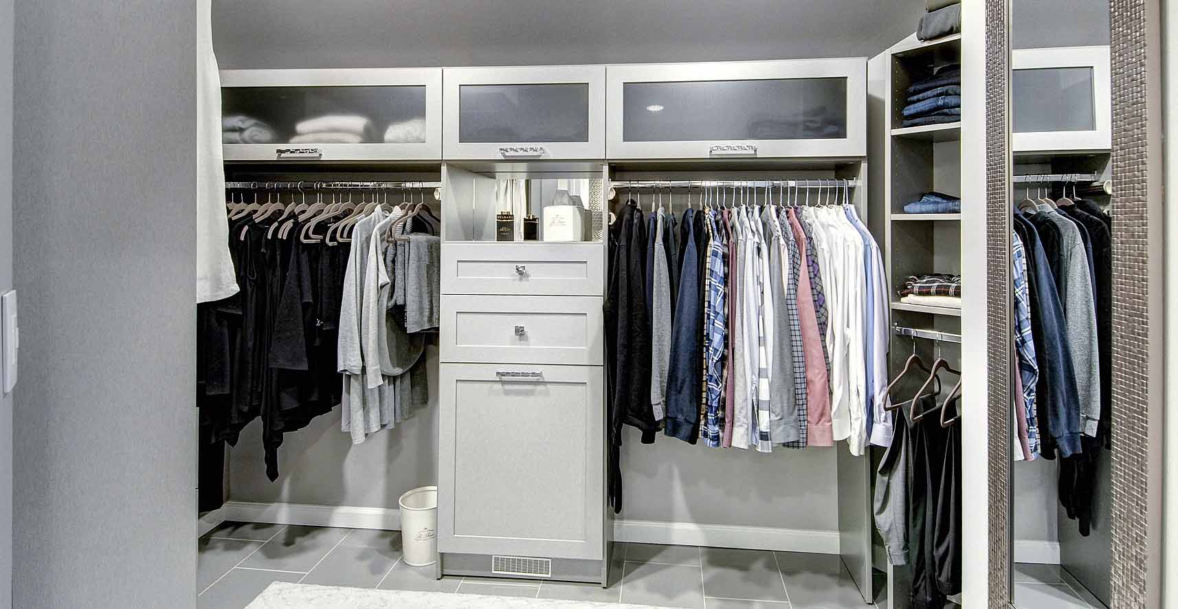 Organized clothes stored in walk in closet system
