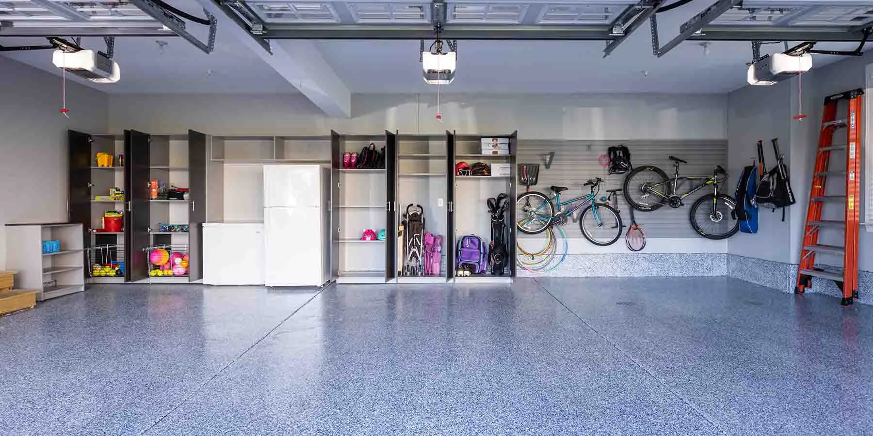 Open custom garage cabinets and wall unit organizing outdoor gear