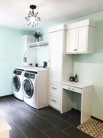 Custom built mudroom with white cabinets and washer dryer