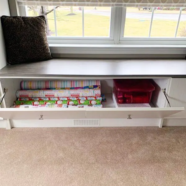 Storing bulky holiday wrapping paper and gear under seating area