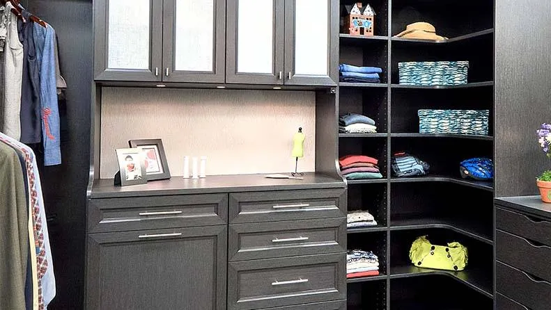 Organized walk-in closet with built-in cabinetry and shelving.