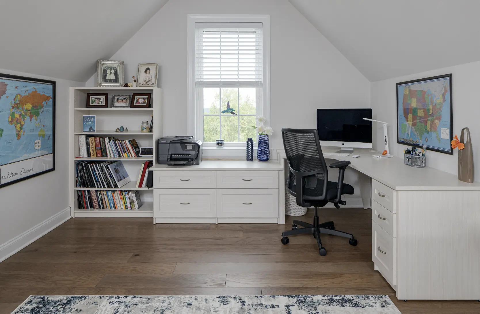 Home office finished with white cabinets in attic room with low ceilings