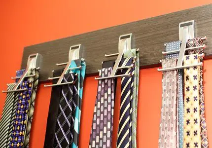 Ties hung neatly on tie rack against a wall