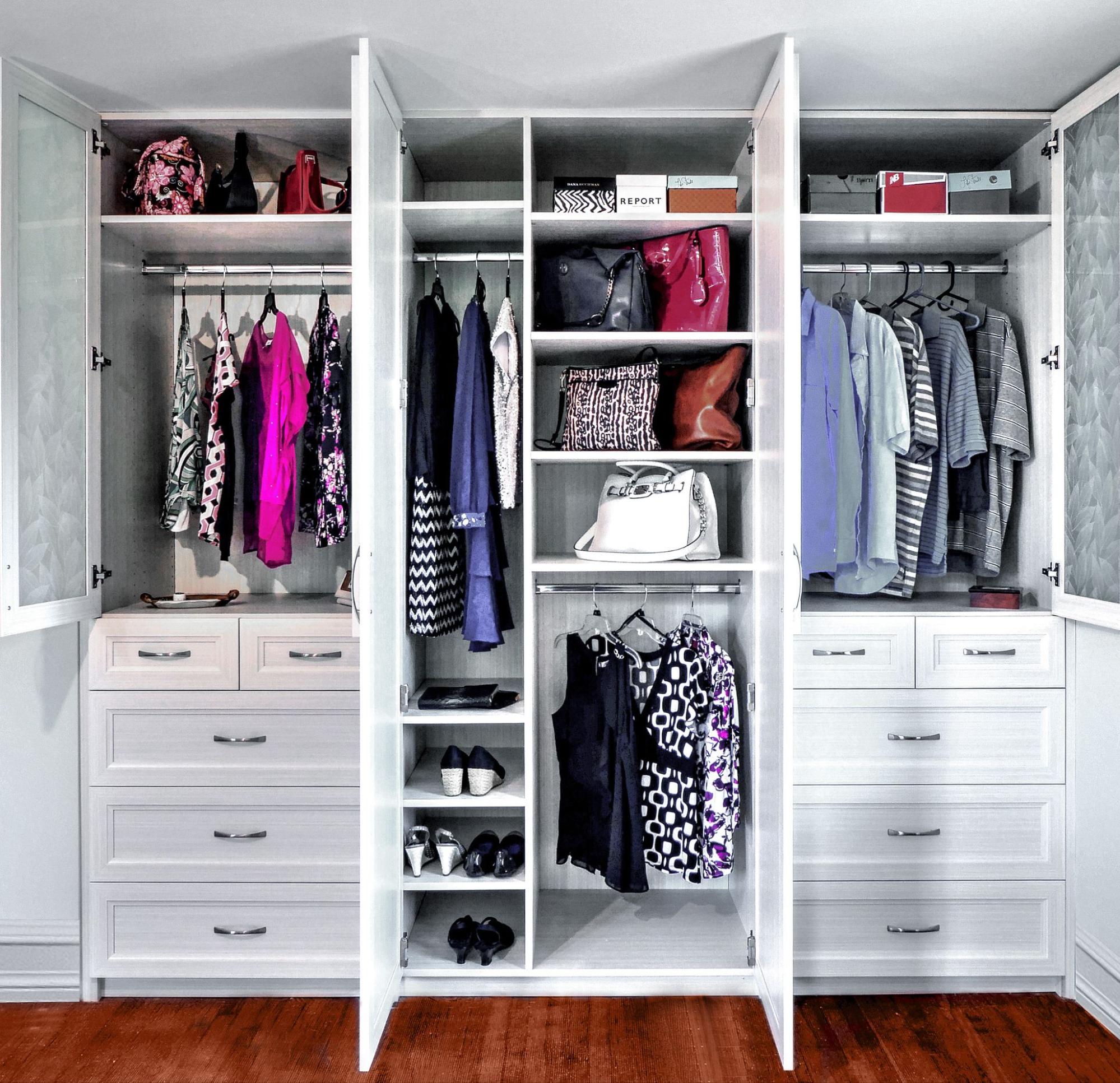 Custom white built-in closet with hanging sections, shelves, drawers, shoe storage, and built-in cabinetry.